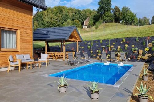 a patio with a pool and chairs and a pavilion at Holiday Home Wi niowa with Pool and Mountain Views in Iwierzyce