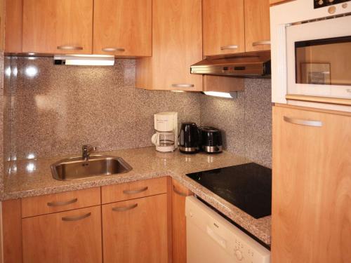 une cuisine avec un évier et un micro-ondes dans l'établissement Bel appartement 2 pièces, accès pistes, Les Orres - FR-1-322-652, aux Orres