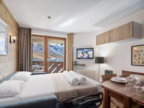 une chambre avec un lit, un bureau et une fenêtre dans l'établissement Val Thorens: Confort moderne, 4 pers, parking inclus - FR-1-640-66, à Val Thorens