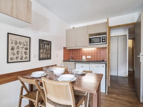 - une cuisine avec une table et des chaises en bois dans la chambre dans l'établissement Val Thorens: Confort moderne, 4 pers, parking inclus - FR-1-640-66, à Val Thorens