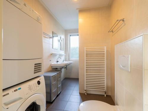 a bathroom with a washing machine and a sink at Wilgenroos Vakantiepark De Groote Vliet in Wervershoof