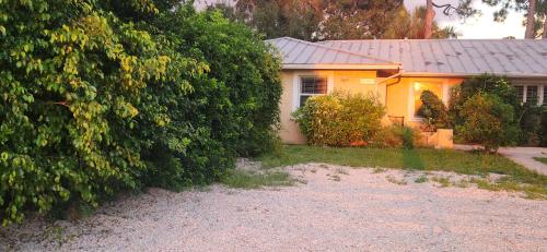 a yellow house with a large bush in front of it at Seagate Cottage in Naples