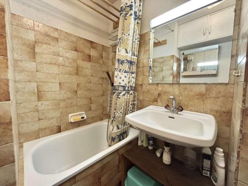 une salle de bain avec un lavabo, une baignoire et un miroir dans l'établissement Studio cabine cosy avec jardin privatif à Praz-Sur-Arly - FR-1-603-110, à Praz-sur-Arly