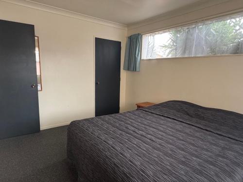 a bedroom with a bed and a window at Accommodation Gateway Motel in Palmerston North
