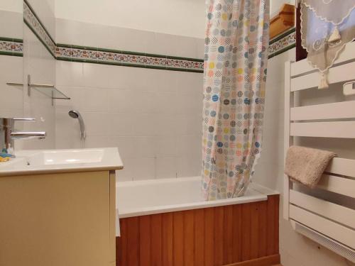 une salle de bain avec une baignoire, un lavabo et un rideau de douche dans l'établissement Studio cabine 4 pers avec parking à Pyrénées 2000 - FR-1-592-72, à Bolquère-Pyrénées 2000