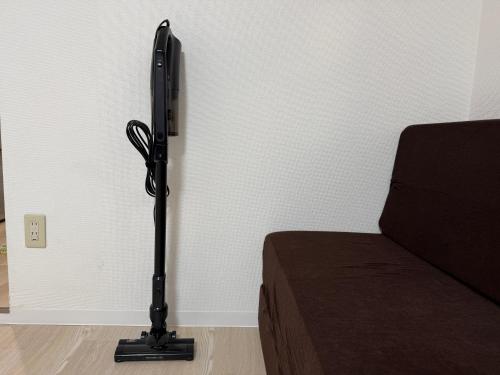 a black lamp next to a bed in a room at Town Court Hosoda in Tokyo