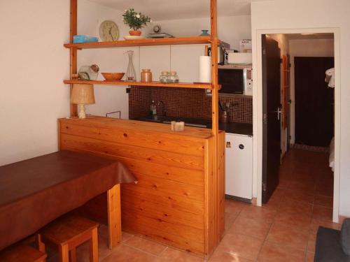 une cuisine avec une armoire en bois et une table dans l'établissement Charmant studio skis aux pieds pour 4 pers. aux Orres - FR-1-322-651, aux Orres