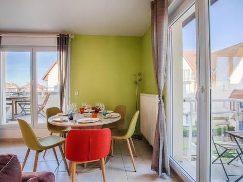 une salle à manger avec une table et des chaises et une fenêtre dans l'établissement Appartement spacieux 70m², piscine, parking, près plage et commerces - FR-1-788-38, à Merville-Franceville-Plage