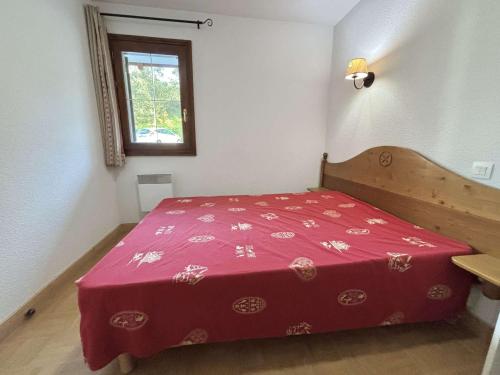 Ce lit rouge se trouve dans une chambre blanche dotée d'une fenêtre. dans l'établissement Appartement 2 pièces à Flumet, aux pieds des pistes, piscine, animaux bienvenus, parking inclus - FR-1-603-111, à Flumet