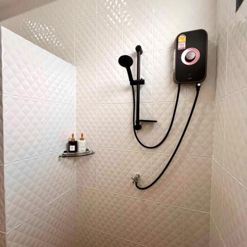 a bathroom with a shower with a camera on the wall at N&D Poolvilla in Ao Nang Beach