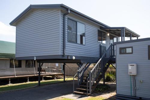 a tiny house with a staircase next to a house at South Coast Retreat in Greenwell Point