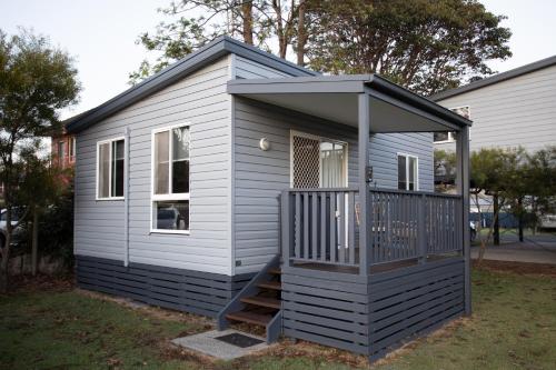 a tiny house with a porch and a deck at South Coast Retreat in Greenwell Point