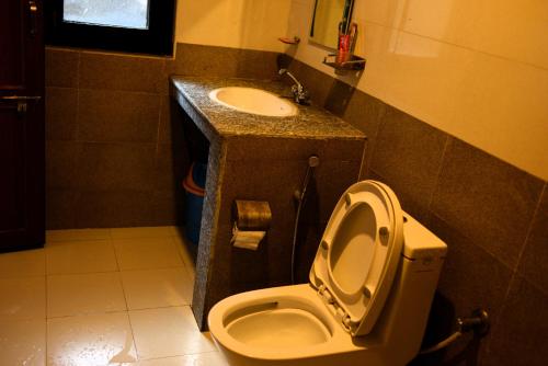 a bathroom with a toilet and a sink at Srijana Farm in Pālpā