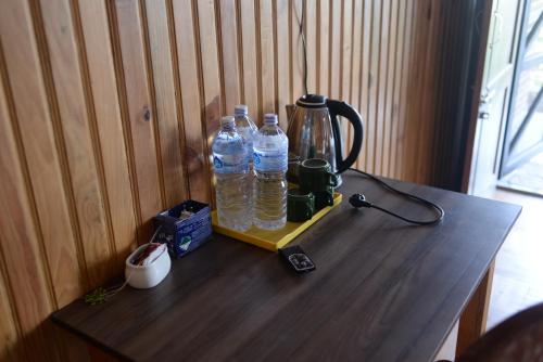 a wooden table with two bottles of water on it at Srijana Farm in Pālpā