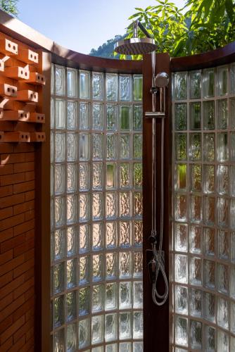 a glass door with a shower in a garden at Amaya Kampot Homestays in Kampot
