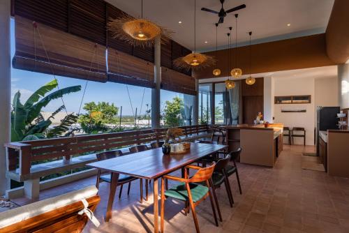 an open kitchen and dining room with a table and chairs at Amaya Kampot Homestays in Kampot