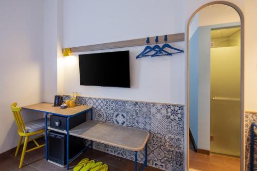 a room with a desk and a tv on a wall at Kampi Hotel Legian in Legian
