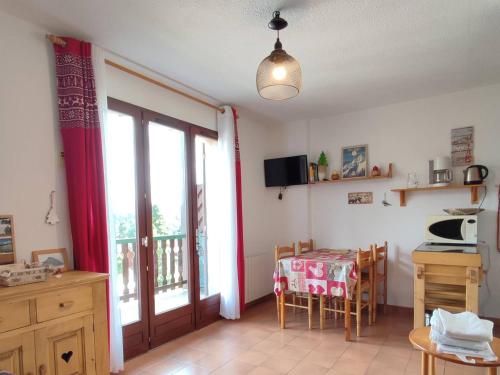 une cuisine avec une table et une table et une fenêtre dans l'établissement Studio cabine 4 pers avec parking à Pyrénées 2000 - FR-1-592-72, à Bolquère-Pyrénées 2000