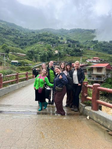 a group of people posing for a picture on a bridge at SaPa Big Tree Hmong Homestay in Sa Pa