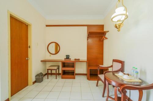 a dining room with a table and a mirror at Royal Brongto Hotel in Timuran