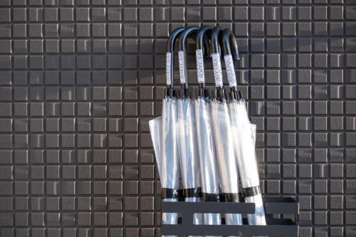 a group of forks hanging on a brick wall at Ici Japon Village in Tokyo