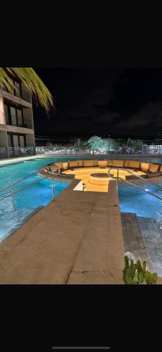a swimming pool at night with blue water at Porto de Galinhas Muro Alto in Porto De Galinhas