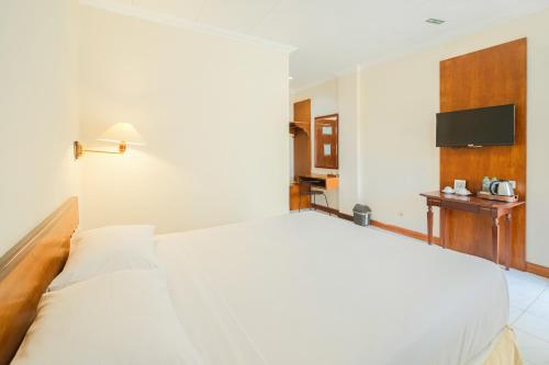 a large white bed in a hotel room at Royal Brongto Hotel in Timuran