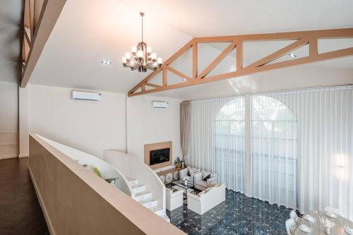 チェンマイにあるSerene Suite 3BR Pool Villa Chiang Maiのリビングルーム(シャンデリア、階段付)