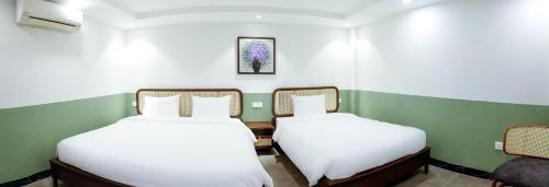 two beds sitting next to each other in a room at Sapa Hai Yen Hotel and Apartment in Sa Pả