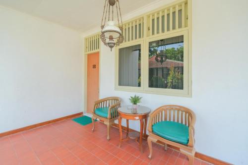 a room with two chairs and a table and a window at Royal Brongto Hotel in Timuran