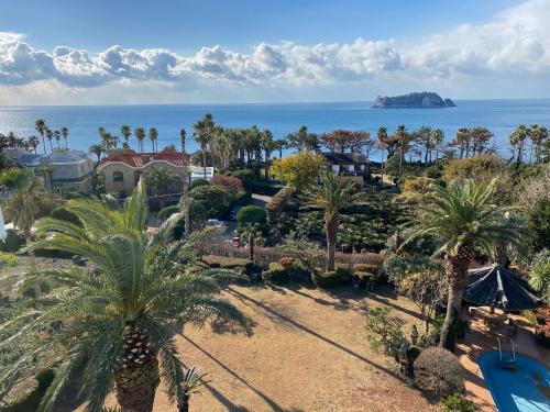 an aerial view of a resort with palm trees and a pool at Rom House in Seogwipo