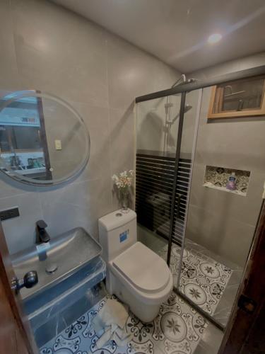 une salle de bain avec toilettes, lavabo et miroir dans l'établissement Edimir Cabin House, à Tagaytay