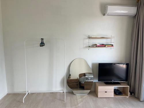 a living room with a flat screen tv and a mirror at Rom House in Seogwipo