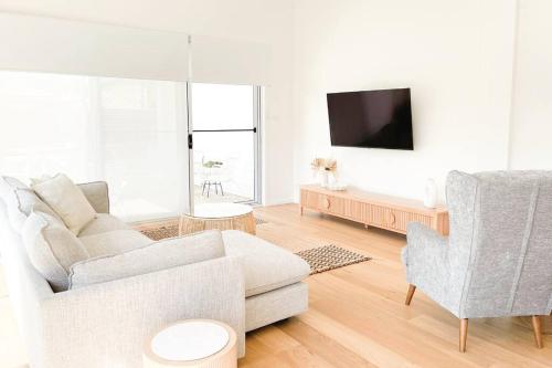 a living room with a couch and two chairs at Red Brick Central Retreat in Wagga Wagga