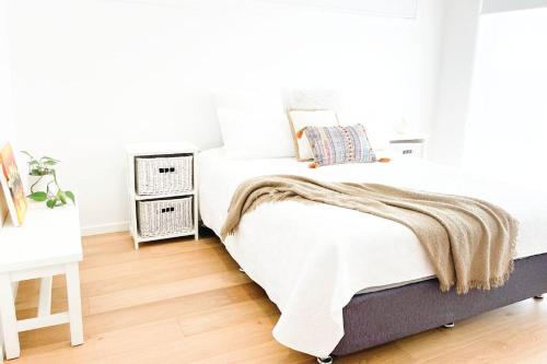 a bedroom with a bed with a blanket on it at Red Brick Central Retreat in Wagga Wagga
