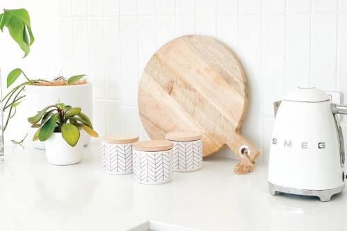 a kitchen counter with a cutting board and four cups at Red Brick Central Retreat in Wagga Wagga