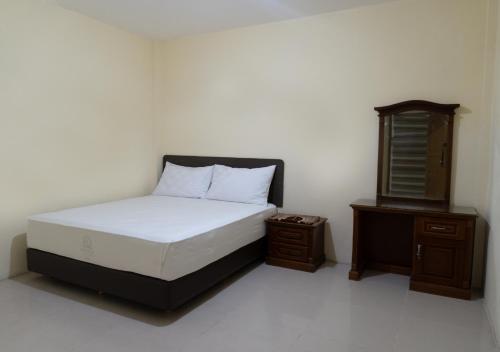 a bedroom with a bed and a nightstand and a bed sidx sidx sidx sidx at Hotel Wisata Banda Aceh in Banda Aceh