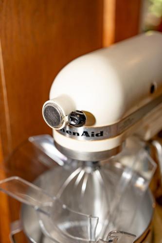 a white mixer sitting on top of a stand at Multi-Level Forest Lodge Near Silverwood with Vintage Ice Cream Parlor & Movie Theater in Spirit Lake