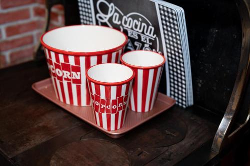 three red and white popcorn buckets sitting on a tray at Multi-Level Forest Lodge Near Silverwood with Vintage Ice Cream Parlor & Movie Theater in Spirit Lake