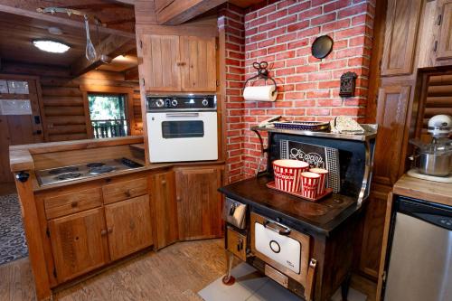 a kitchen with wooden cabinets and a brick wall at Multi-Level Forest Lodge Near Silverwood with Vintage Ice Cream Parlor & Movie Theater in Spirit Lake