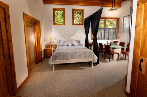 a bedroom with a bed and a table and chairs at Cedar Cabin Near Silverwood in Spirit Lake