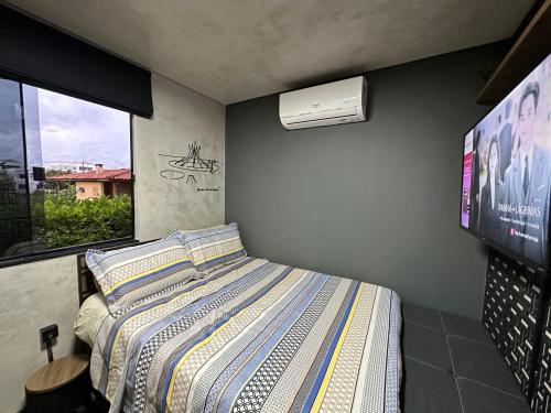 a bedroom with a bed and a tv and a bed sidx sidx sidx at Apê térreo sem escada com Ar Cond, WiFi e banheira! in Brasilia