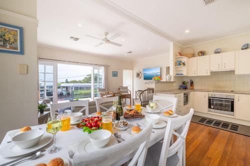 a kitchen and dining room with a table and chairs at Mon Reve 4A Tallean Road three bedroom property with Wi-Fi, air conditioning in Nelson Bay
