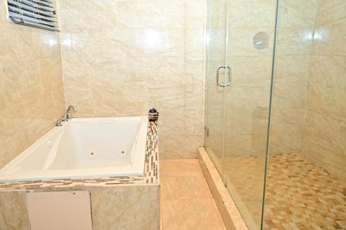 a bathroom with a tub and a glass shower at Luxury home 5 minutes from stadium in Miami