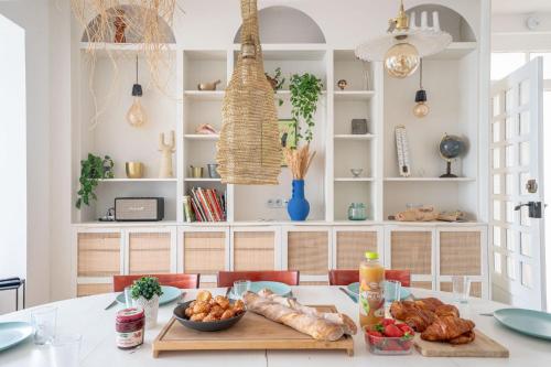 - une cuisine avec une table, du pain et de la nourriture dans l'établissement Belle des Marais, Villa terrasse, plage et bourg à pied, au Pouliguen