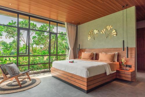 a bedroom with a bed and a large window at Sea View Pool Villa - Exclusive Beachfront Property in Buleleng