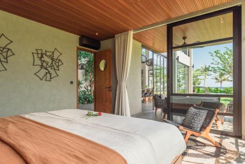 a bedroom with a large bed and a balcony at Sea View Pool Villa - Exclusive Beachfront Property in Buleleng