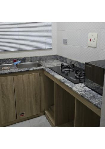 una cocina con fregadero y encimera en BL- Studio Apartment, en Ajegunle