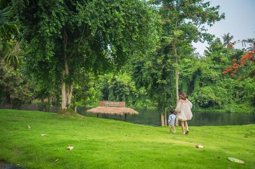 a woman and a child walking in a park at Villa De Leaf River Kaeng Krachan in Phetchaburi