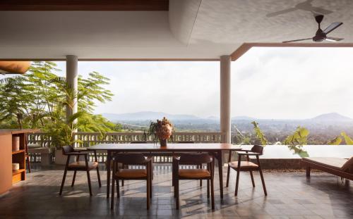 a dining room with a table and chairs on a balcony at Amaya Kampot Homestays in Kampot